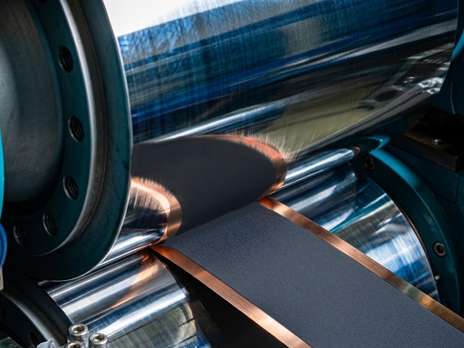 A coated electrode passing between polished steel calendering rollers