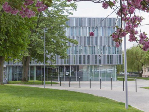 The glass facade of the LRCS research laboratory, framed by cherry blossom