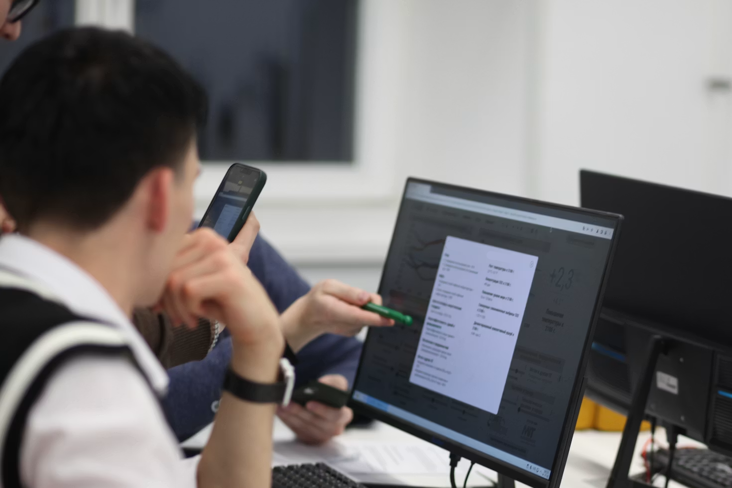 Two engineers reviewing model outputs on a monitor during a training session